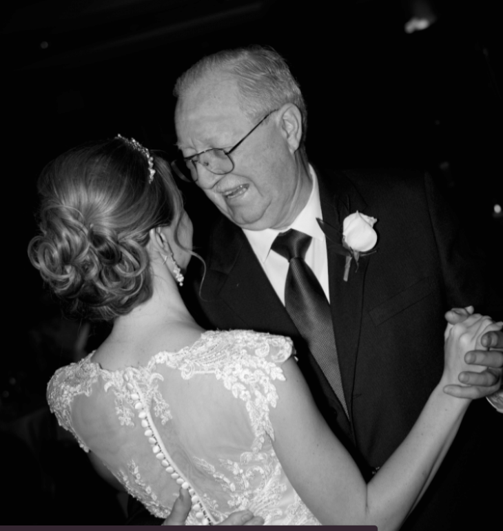 A bride and her father dancing while getting event photography services