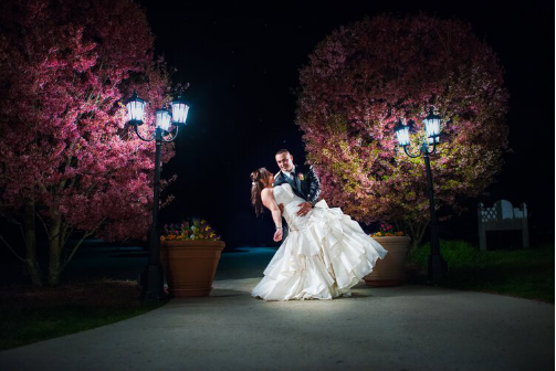 Professional wedding photographer capturing a bride and groom in a romantic pose