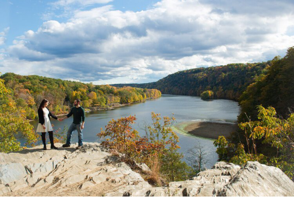 a couple standing next to a lake