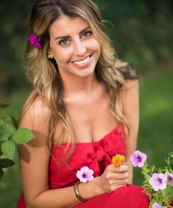 a woman sitting in her garden and smiling