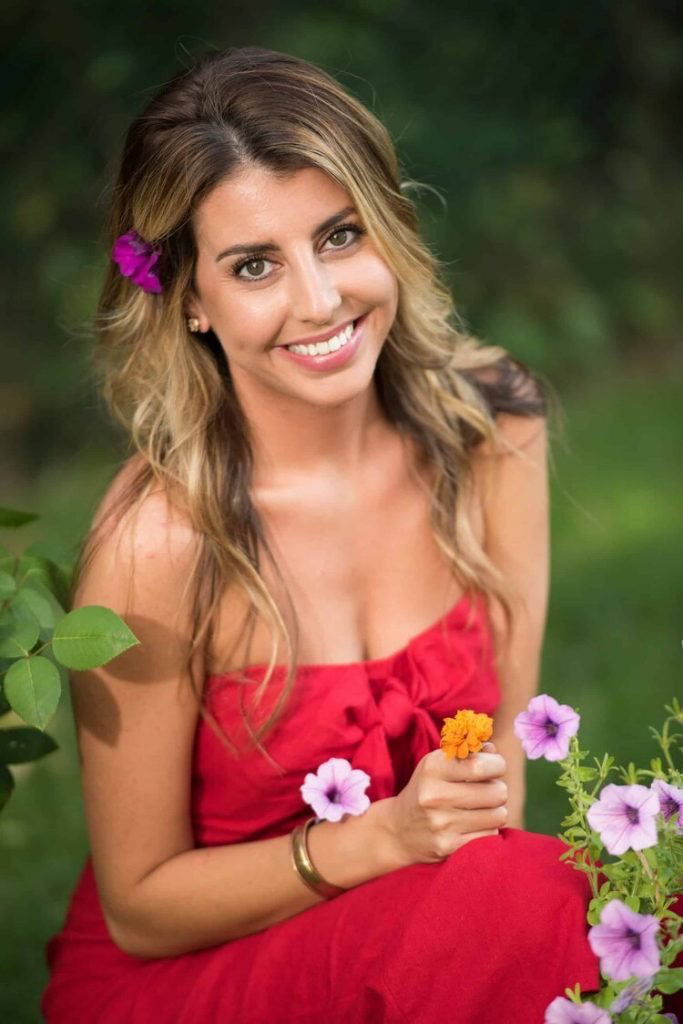 a woman sitting in her garden and smiling